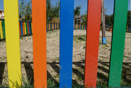 foto de la valla de un parque infantil, con colores primarios, amarillo,naranja,azul,rojo y verde